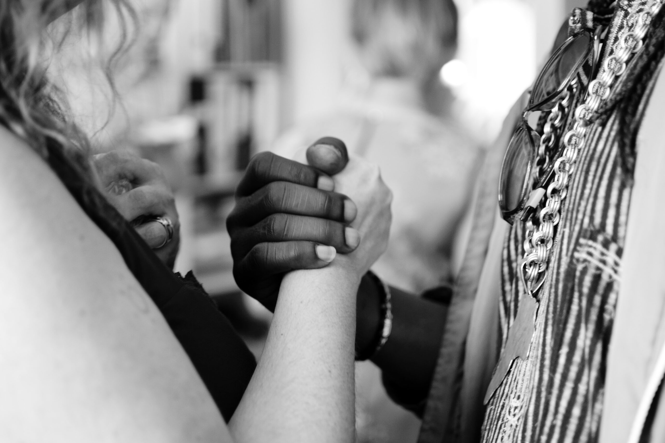 Two people holding hands showing support of financial therapy.