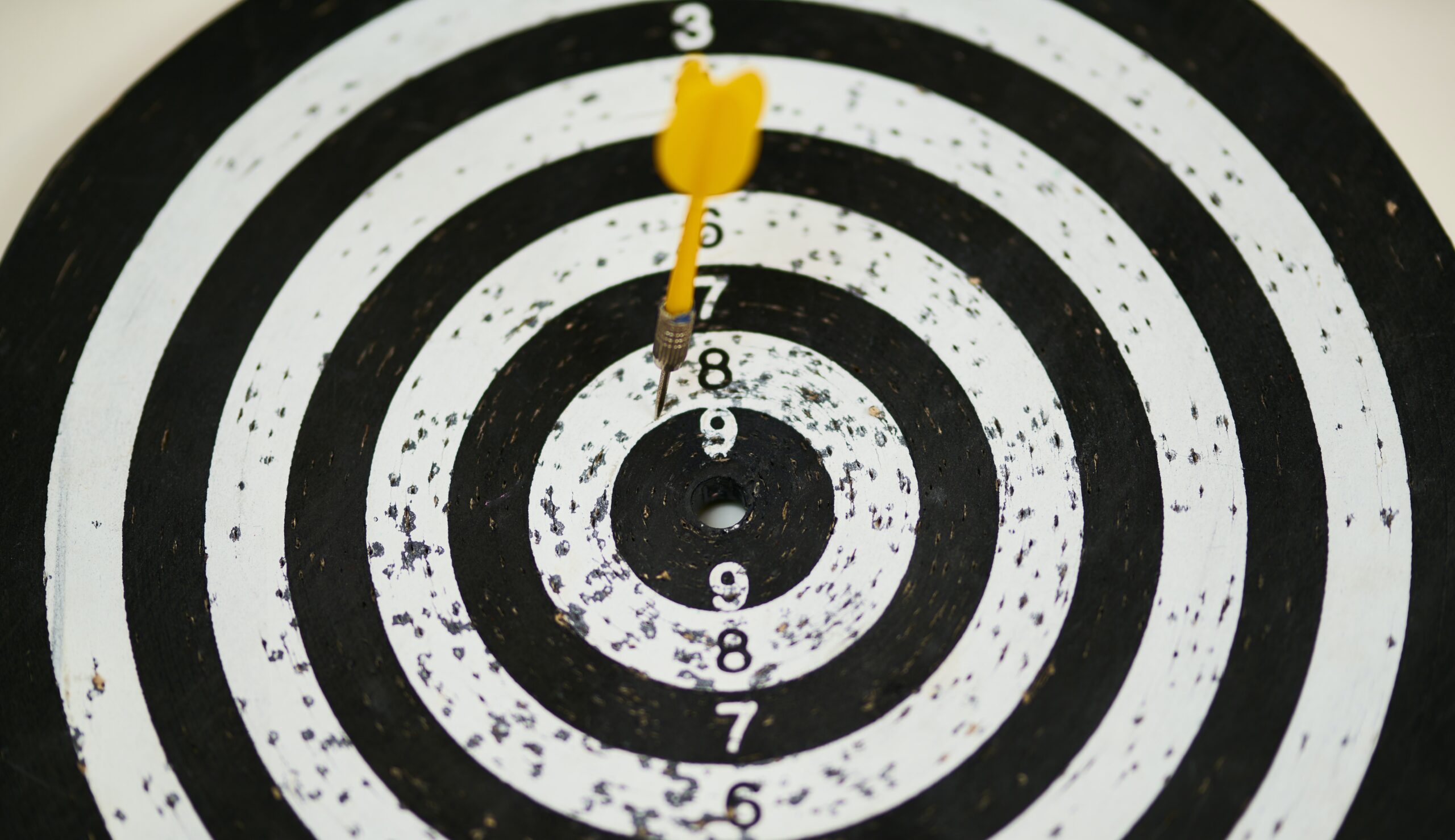 Dart in bullseye representing a financial coach helping someone achieve their goals