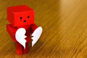 Figurine holding a broken heart after divorce