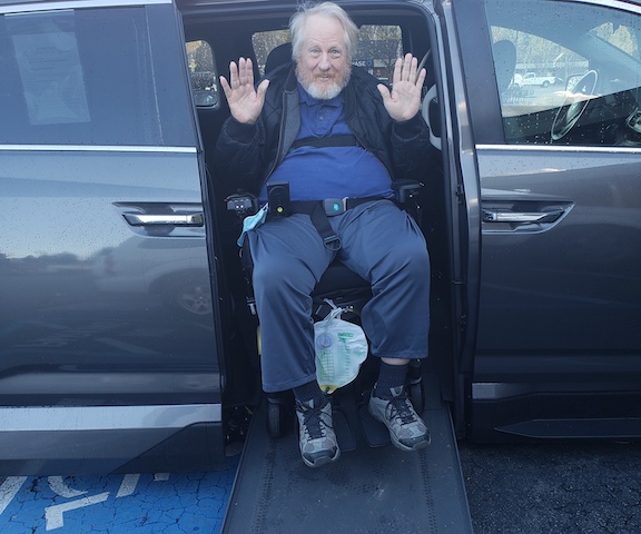 Robert in a wheelchair coming out of his van