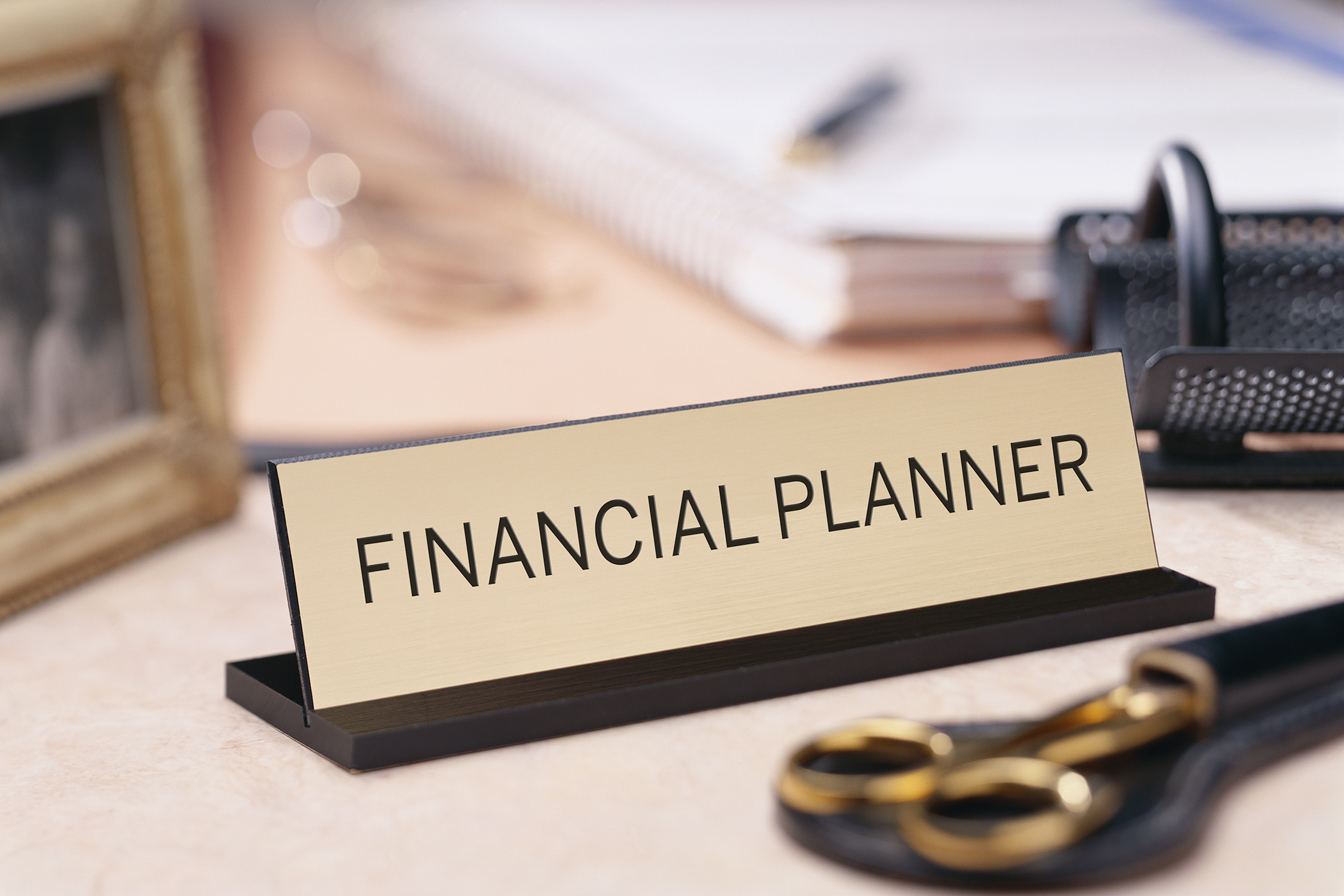 A financial planner placard sits on a CFP's desk.